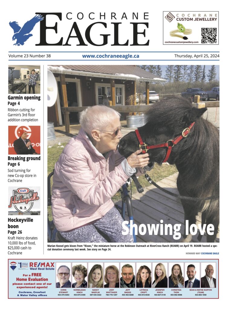 A woman petting a horse on the front page of an eagle newspaper.